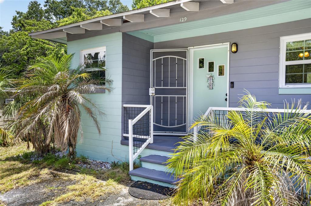 The exterior of a house features a light blue and gray facade with a front porch — 129 COLOMBA ROAD, DEBARY, FL