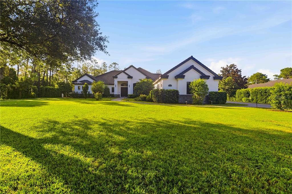 An aerial view of a white house with a dark tiled roof and pool enclosure — 21724 DEER POINTE CROSSING, BRADENTON, FL