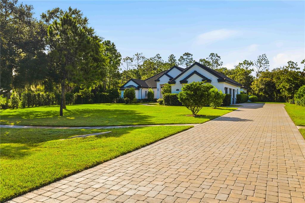 A covered patio features a stone fire pit, a ceiling fan, and a screened-in pool area — 21724 DEER POINTE CROSSING, BRADENTON, FL