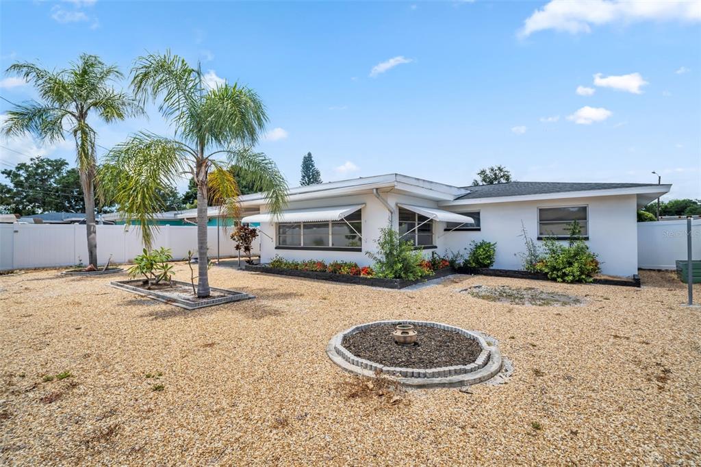 A single-story white house with a gravel yard, palm trees, and window awnings — 2301 WHITMAN STREET, CLEARWATER, FL