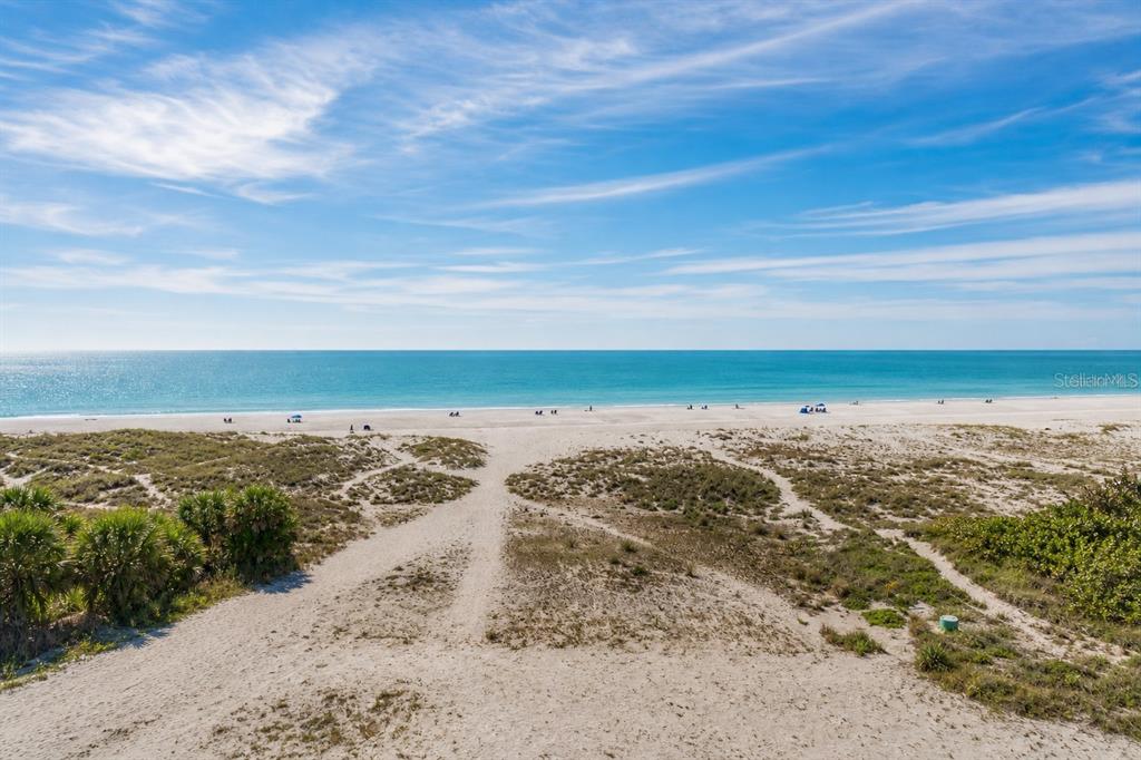 A sandy path leads through dunes toward a beach and the ocean under a blue sky — 10116 GULF BOULEVARD UNIT 201W, TREASURE ISLAND, FL