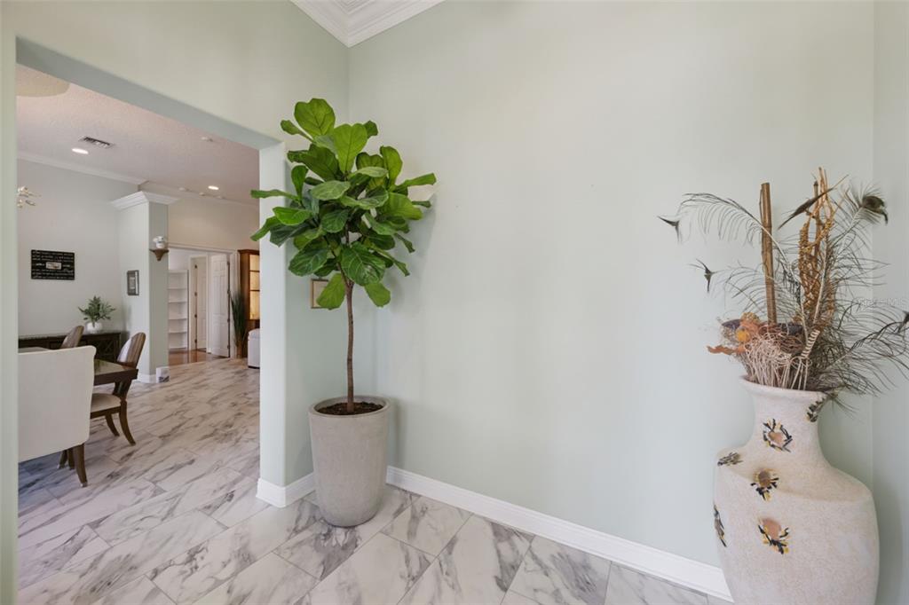 A yellow house features a circular stone driveway and a detached garage — 12128 LAKESHORE DRIVE, CLERMONT, FL