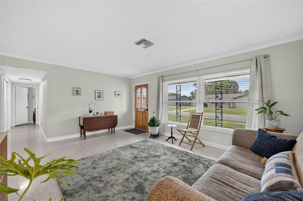 A living room features light walls, terrazzo flooring, a front door, and a large window — 619 MARSHALL STREET, ALTAMONTE SPRINGS, FL