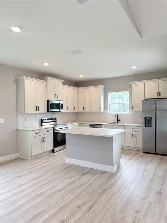 A dining room features a wooden table, four yellow chairs, and a white sliding barn door — 5336 COLUMBUS BOULEVARD, SEBRING, FL
