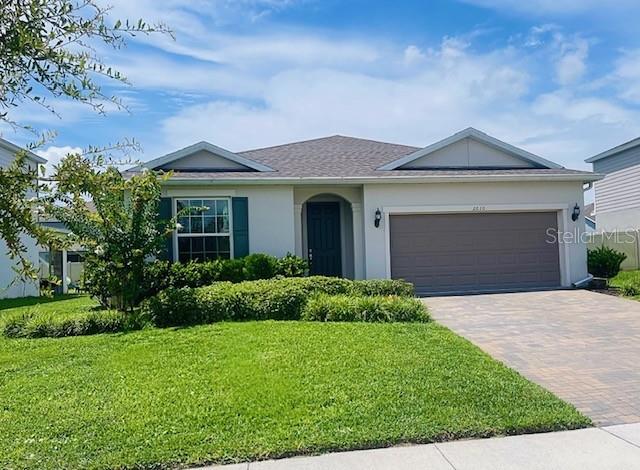 A paved walkway leads to a covered front entryway with a dark green door — 2610 HILLTOP LOOP, APOPKA, FL