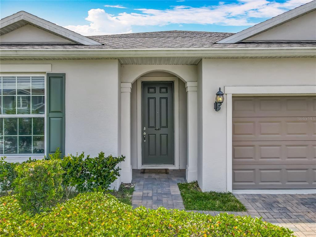 A hallway with wood-look flooring, a patterned runner rug, and a mirrored wall console table — 2610 HILLTOP LOOP, APOPKA, FL