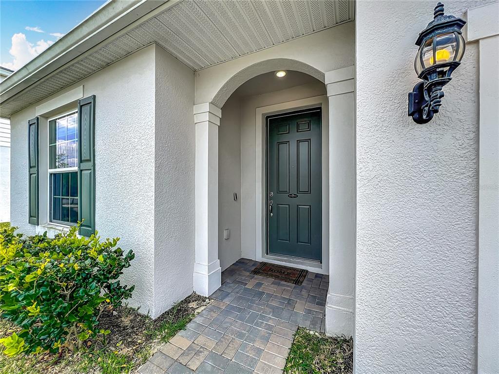 An entryway with wood-look flooring leads into a carpeted living room through a curtained opening — 2610 HILLTOP LOOP, APOPKA, FL