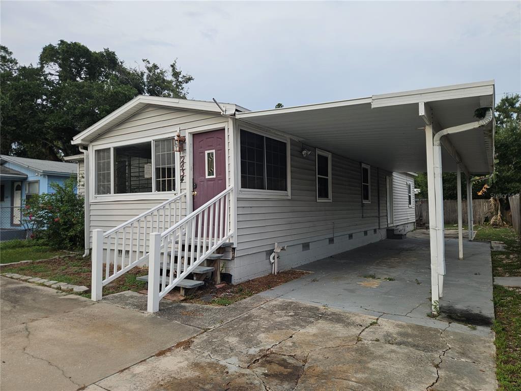 A single-story house with light gray siding, a purple front door, and an attached carport — 2434 37TH STREET S, ST PETERSBURG, FL