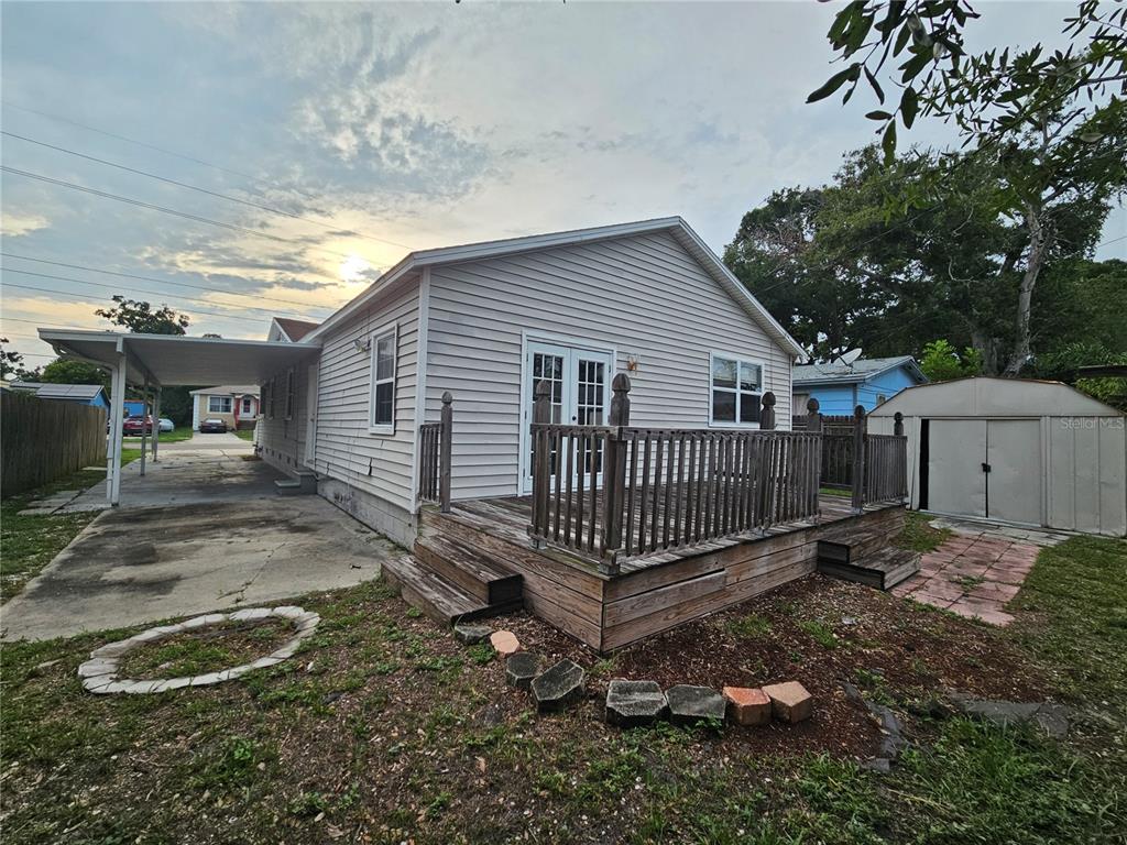 The exterior of a house features a wooden deck, a carport, and a storage shed — 2434 37TH STREET S, ST PETERSBURG, FL