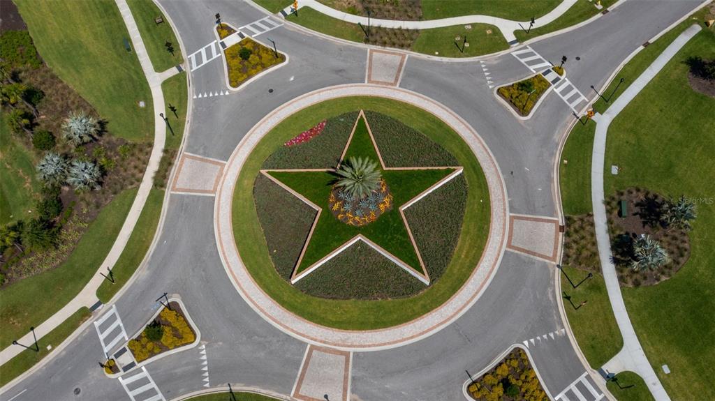An aerial view of a circular roundabout featuring a large star-shaped landscaped center island — 3723 COUNTRY VIEW COURT, BRADENTON, FL