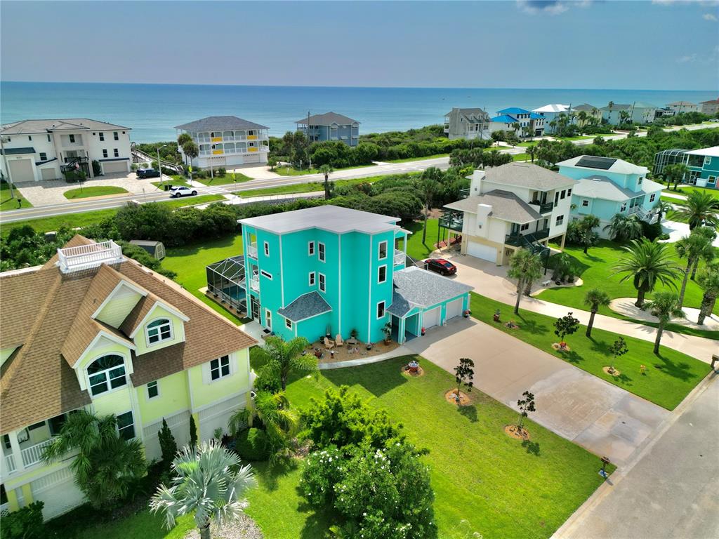 An aerial view shows a bright teal house with a pool and a large driveway — 3073 PAINTERS WALK, FLAGLER BEACH, FL