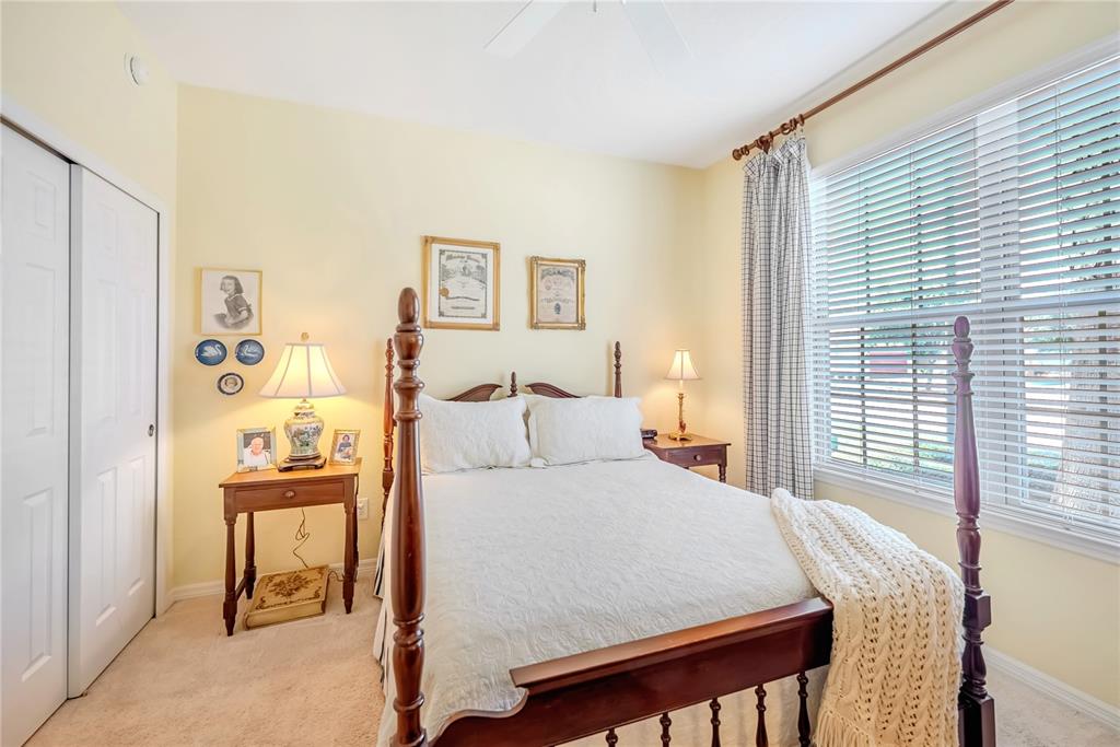 A bedroom features a four-poster bed, two nightstands with lamps, and a window with blinds — 9145 SW 70TH LOOP, OCALA, FL