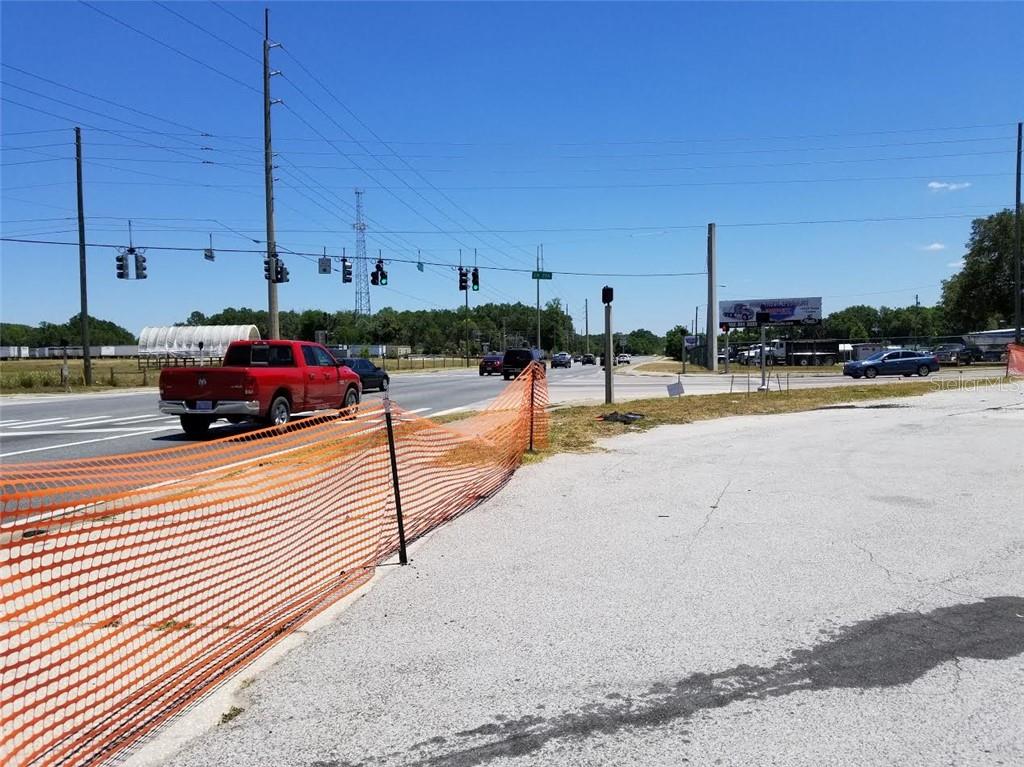 An outdoor view of a road intersection with a red pickup truck and orange fencing — 3520 W HIGHWAY 326 HIGHWAY, OCALA, FL
