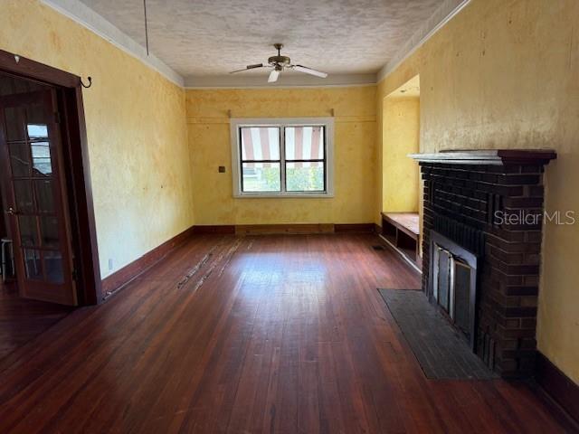A living room features hardwood floors, yellow walls, a brick fireplace, and a ceiling fan — 1600 E LAKEVIEW AVENUE, EUSTIS, FL