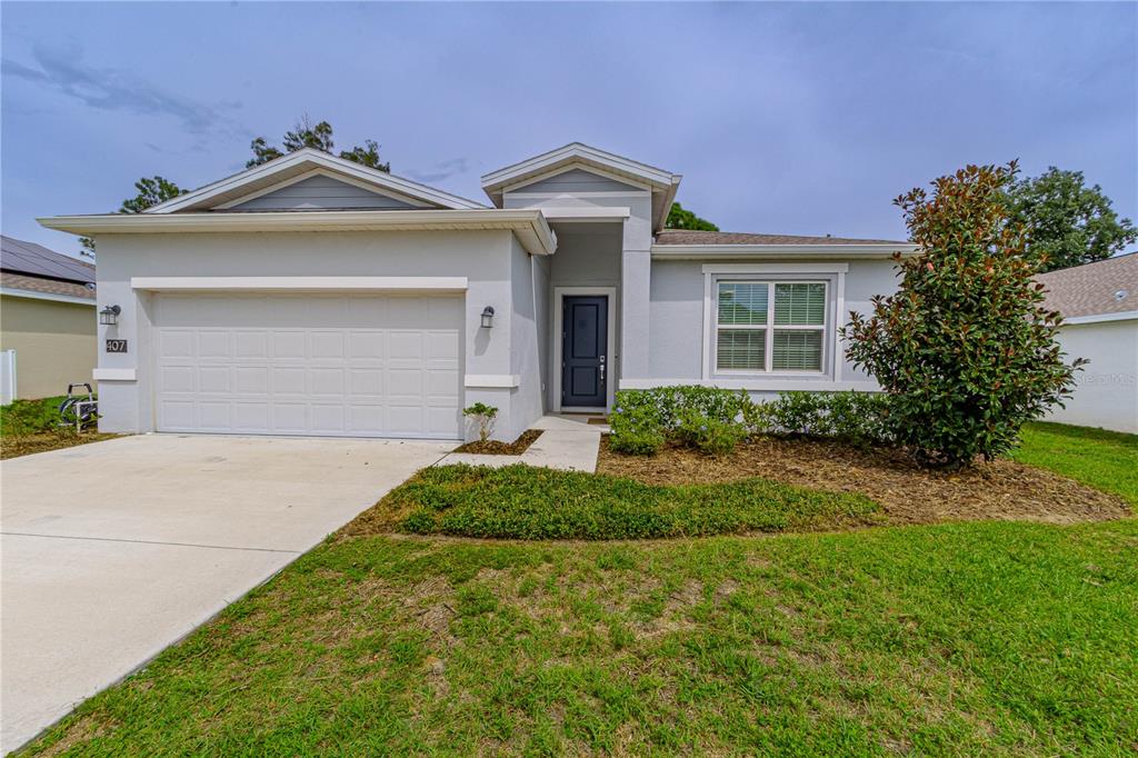 A kitchen features white cabinets, stainless steel appliances, and a peninsula with a sink — 407 THREE OAKS DRIVE, EDGEWATER, FL