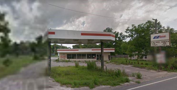 An abandoned gas station with a canopy and a sign stands on a grassy lot — 1308 S DIXIE HIGHWAY, PERRY, FL