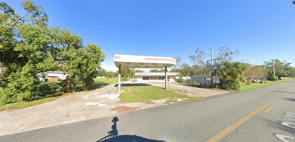 An exterior view of a vacant, single-story commercial building with a large covered fuel canopy — 1308 S DIXIE HIGHWAY, PERRY, FL