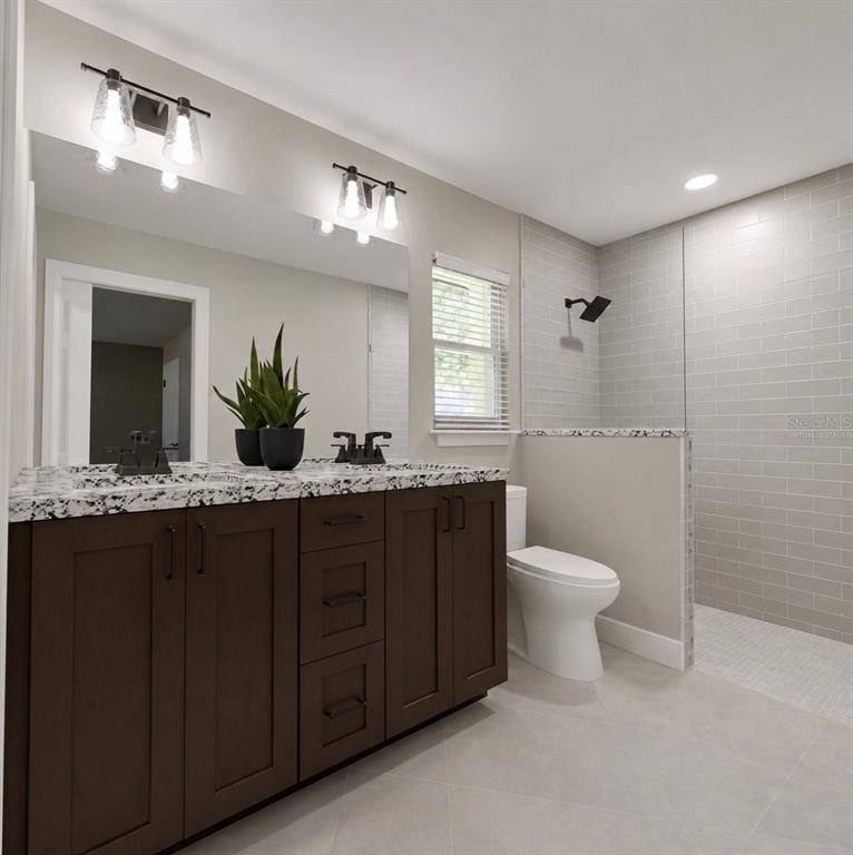 A bathroom features a dark wood vanity with a speckled countertop, a mirror, and a shower — 50 BAY DRIVE, OCKLAWAHA, FL