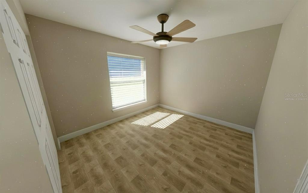 This is a virtually staged bedroom with light-colored walls, wood-look flooring, and a ceiling fan — 50 BAY DRIVE, OCKLAWAHA, FL