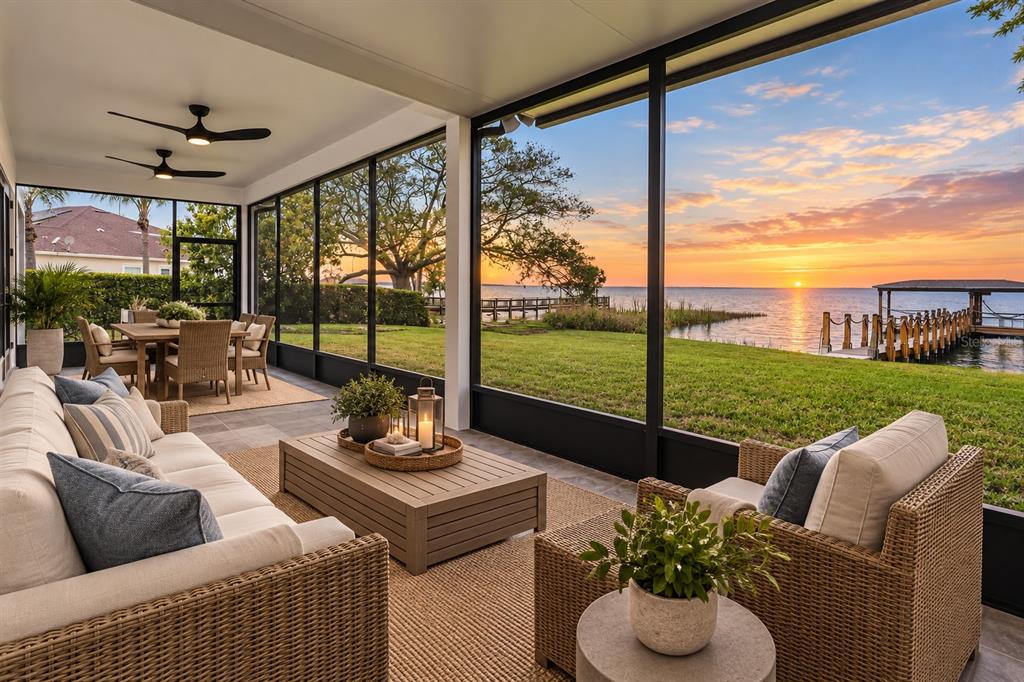 An aerial view shows a two-story house with a three-car garage beside a lake — 243 ZACHARY WADE STREET, WINTER GARDEN, FL