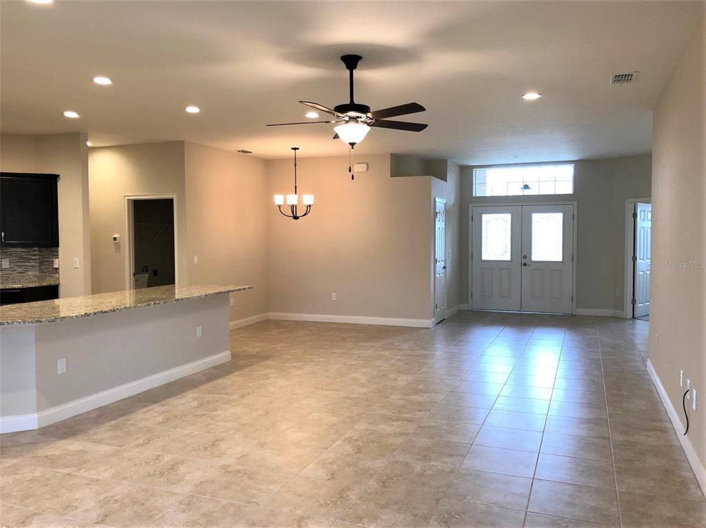 An open-concept living area features tile flooring, a kitchen island, and a ceiling fan — 6063 HIGHLANDS GRACE BOULEVARD, LAKELAND, FL