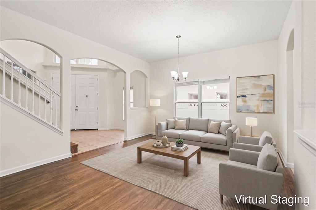 An empty dining room with wood-look flooring, a chandelier, and an arched entryway — 10546 WILLOW RIDGE LOOP, ORLANDO, FL