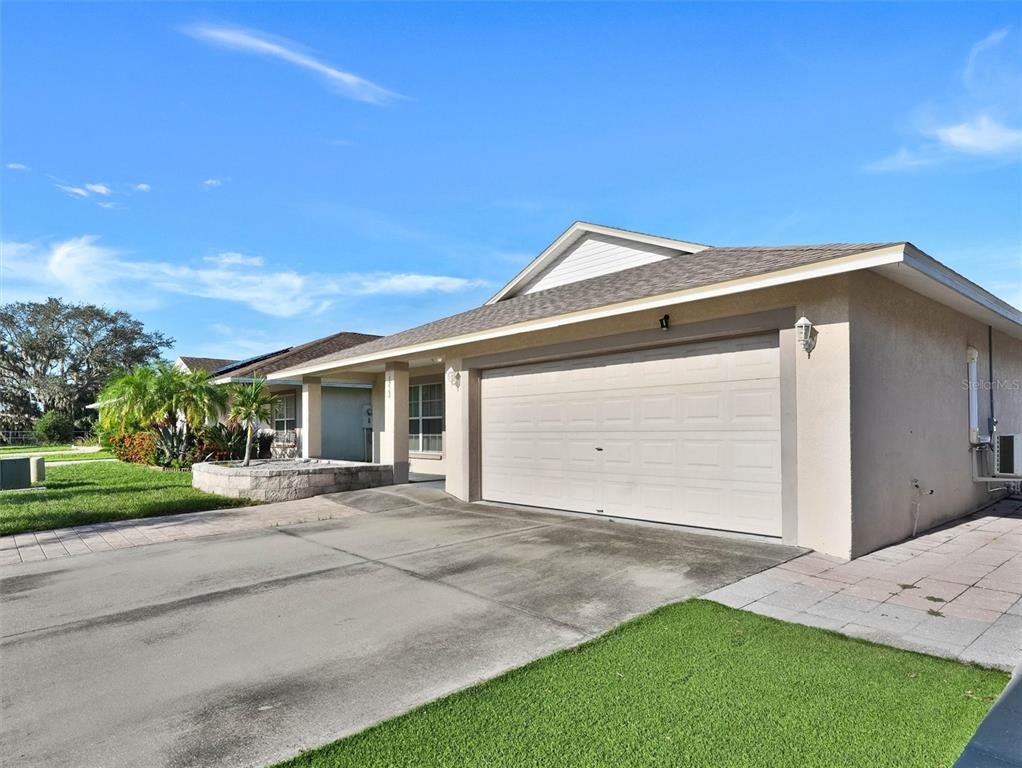 A single-story house features a two-car garage, a concrete driveway, and a small lawn — 1213 HUMBLE HAVEN STREET, RUSKIN, FL