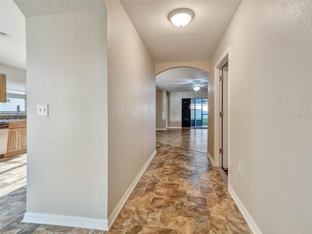 A backyard with artificial turf, a white vinyl fence, and a house with a screened-in patio — 1213 HUMBLE HAVEN STREET, RUSKIN, FL