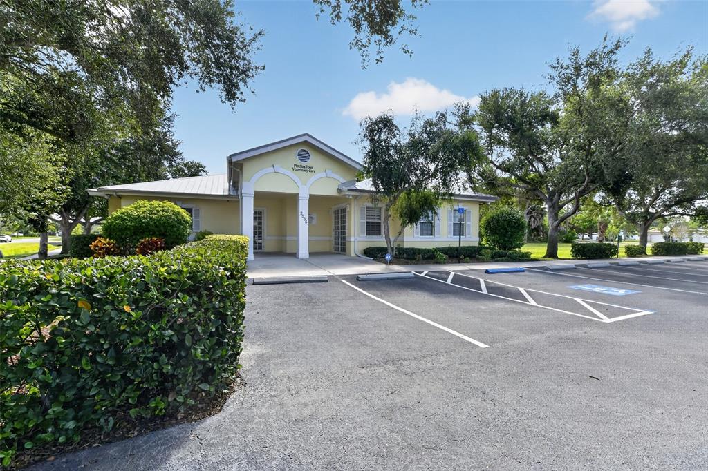 A single-story veterinary clinic building features a yellow exterior, a covered entrance, and parking spaces — 2555 PINELLAS POINT DRIVE S, ST PETERSBURG, FL