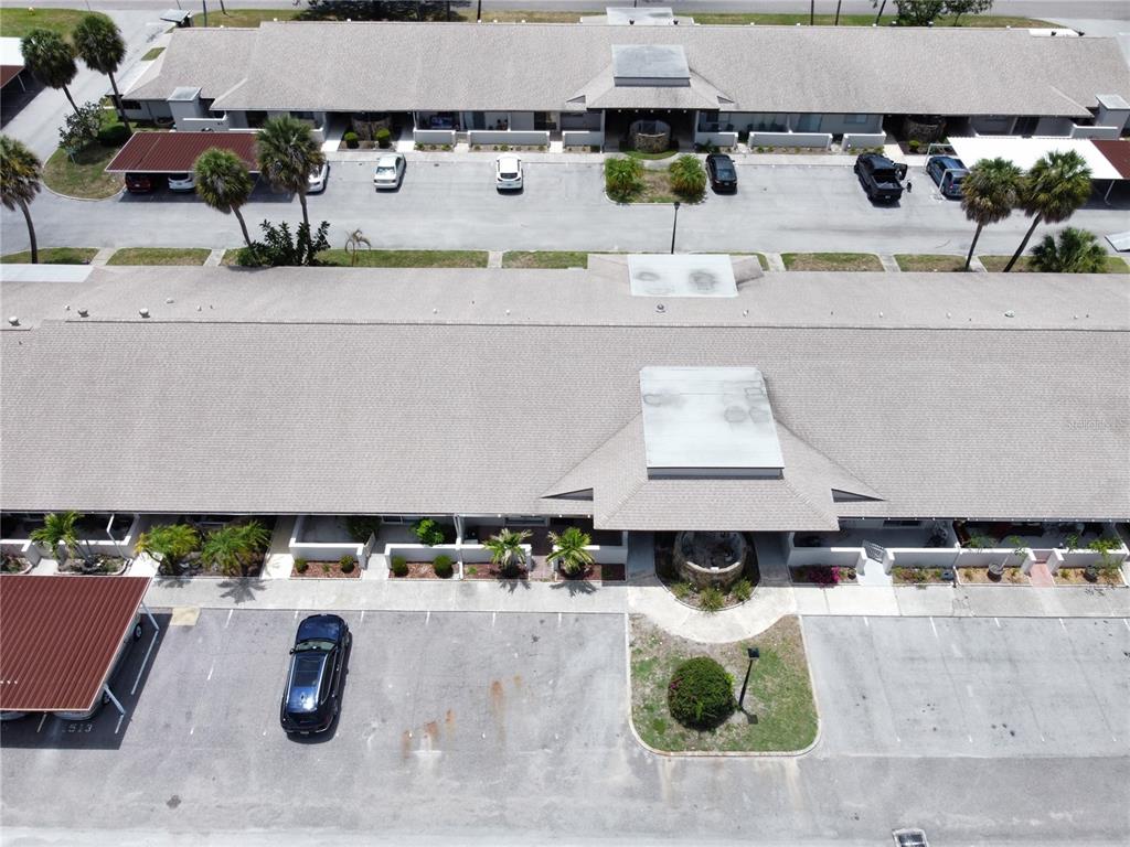 An aerial view shows two long, single-story apartment buildings with parking lots and palm trees — 1513 16TH CIRCLE SE UNIT 43, LARGO, FL