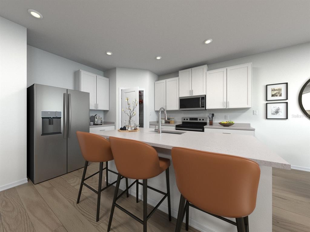 This is a rendering of a modern kitchen featuring white cabinets, stainless appliances, and island seating — 1756 FOREST RUN LANE, AUBURNDALE, FL