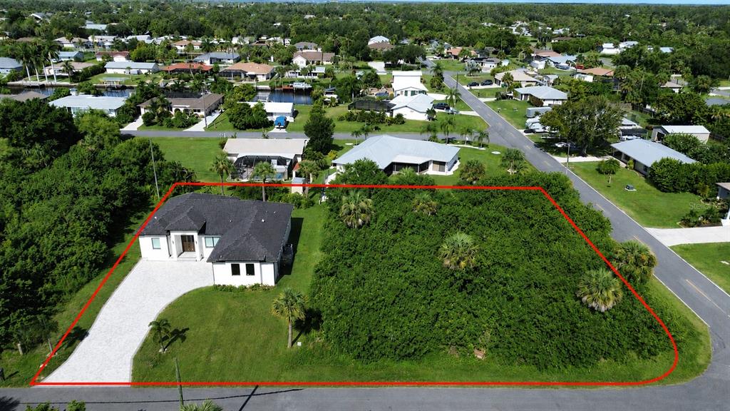 An aerial view shows a house with a large adjacent vacant lot outlined in red — 4317 MEAGER CIRCLE, PORT CHARLOTTE, FL