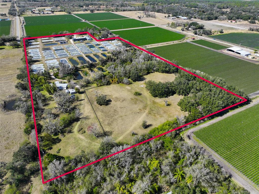 An aerial view shows a rural property with numerous aquaculture ponds and surrounding agricultural fields — 20112 HOBBS ROAD, WIMAUMA, FL