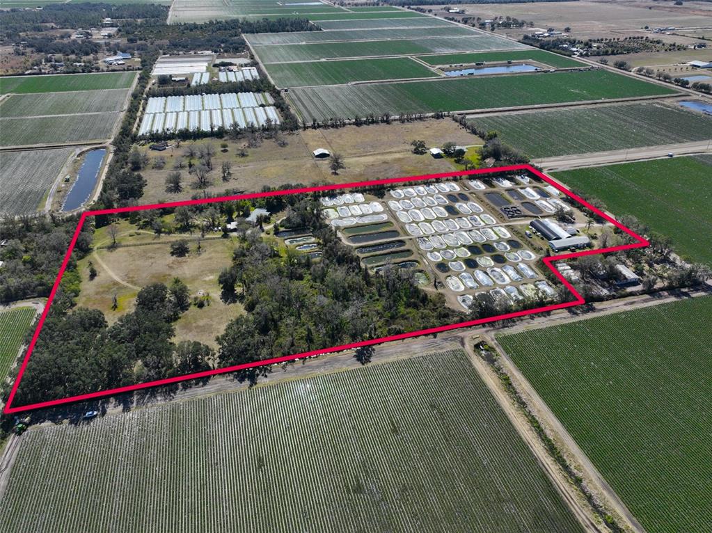 An aerial view shows a rural property with numerous small ponds and agricultural fields — 20112 HOBBS ROAD, WIMAUMA, FL