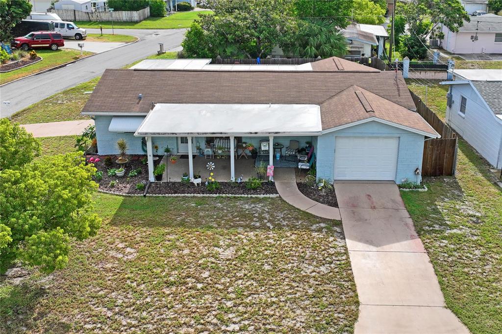 An aerial view of a single-story light blue house with a brown roof and carport — 7106 PALISADE DRIVE, PORT RICHEY, FL