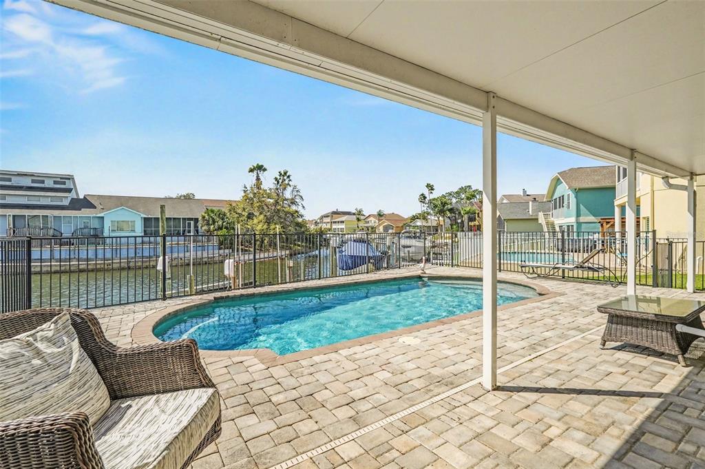 A concrete patio overlooks a canal with a boat lift, a dock, and a jet ski — 6340 SPOONBILL DRIVE, NEW PORT RICHEY, FL