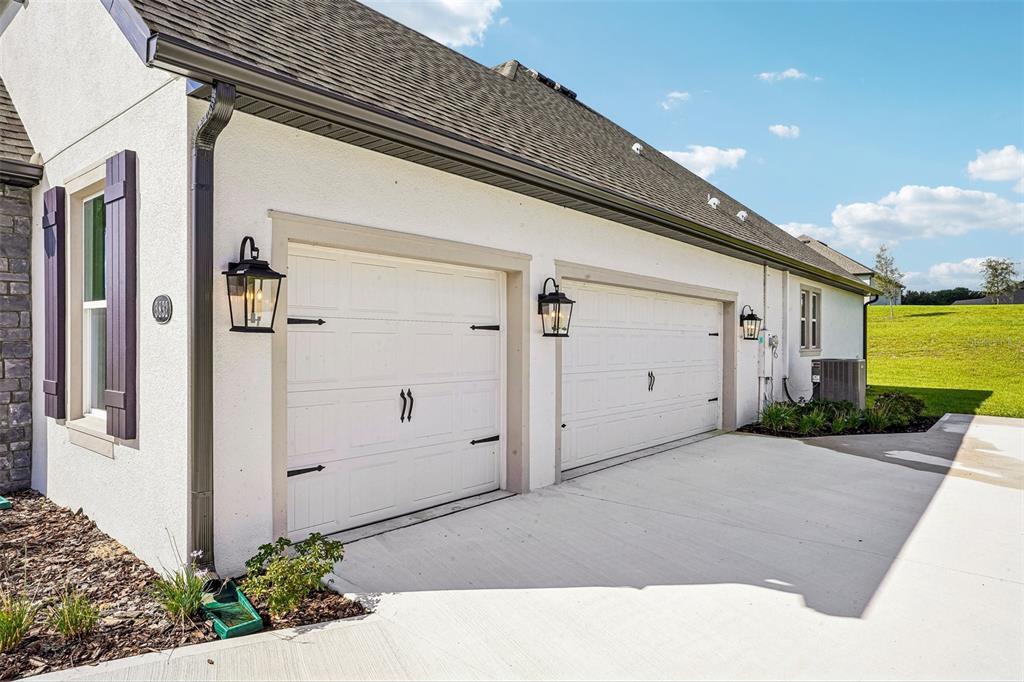 A modern kitchen features white cabinetry, stainless steel appliances, a gray island, and light flooring — 3832 SADDLE HILL TRAIL, FRUITLAND PARK, FL