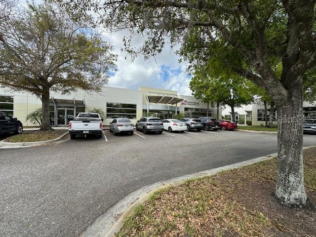 A parking lot in front of a commercial office building with several parked cars — 8810 COMMODITY CIRCLE UNIT 12, ORLANDO, FL