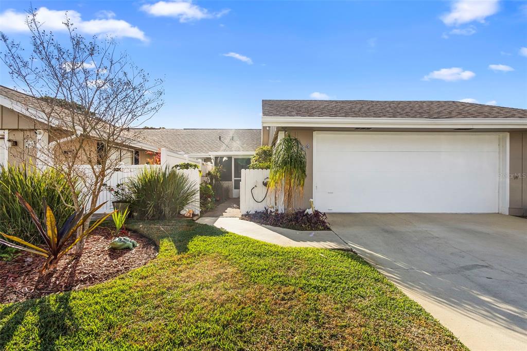 A single-story house exterior features a white garage door, a concrete driveway, and a walkway — 44 FORE DRIVE, NEW SMYRNA BEACH, FL