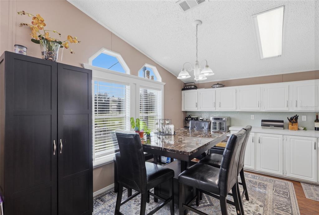 A living room features a large television, brown furniture, a patterned rug, and a ceiling fan — 28651 TUPPER ROAD, WESLEY CHAPEL, FL