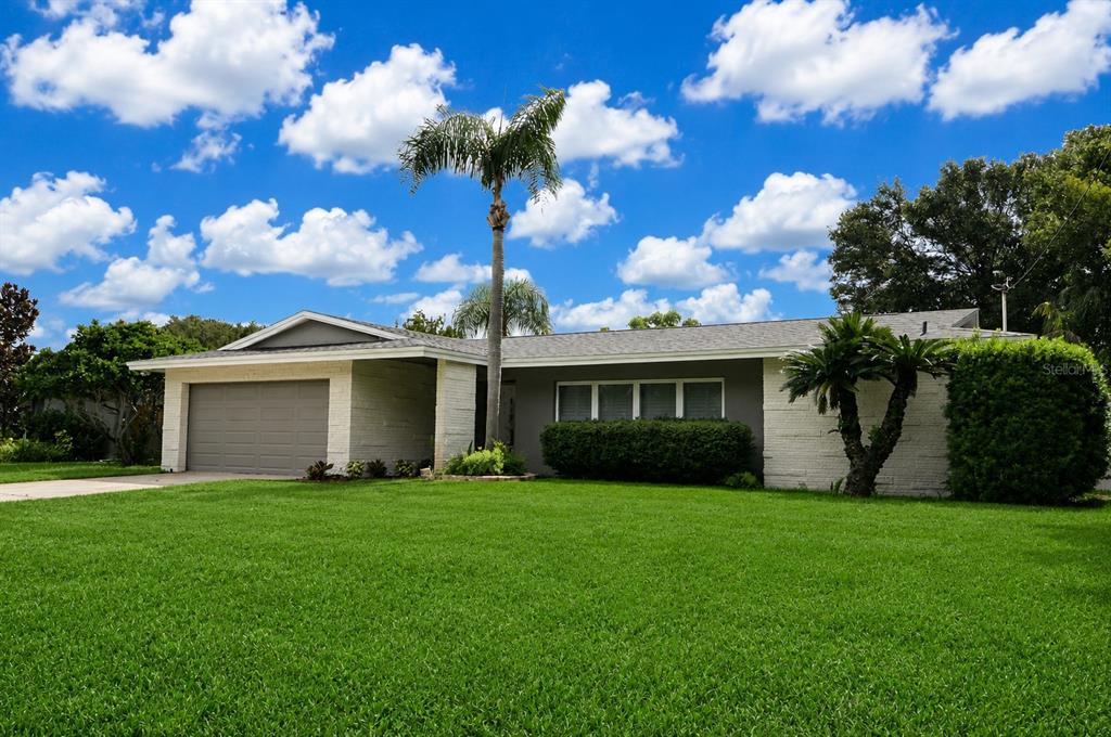 A single-story house with a gray exterior, a two-car garage, and a palm tree — 981 DAMROSCH STREET, LARGO, FL