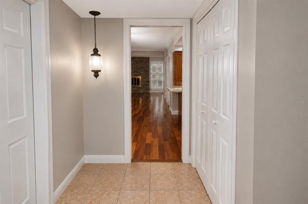 A tiled entryway leads through a doorway into a room with hardwood floors and a fireplace — 981 DAMROSCH STREET, LARGO, FL