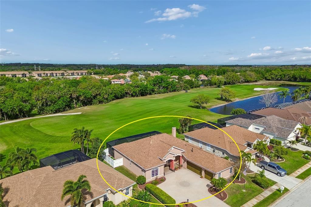 An aerial view of a single-story house with a brown roof and a circular driveway — 566 PLANTERS MANOR WAY, BRADENTON, FL