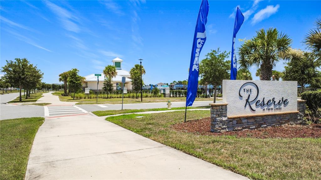 A stone monument sign for The Reserve at Twin Lakes stands near a sidewalk and crosswalk — 5183 BUTTONSAGE DRIVE, ST CLOUD, FL