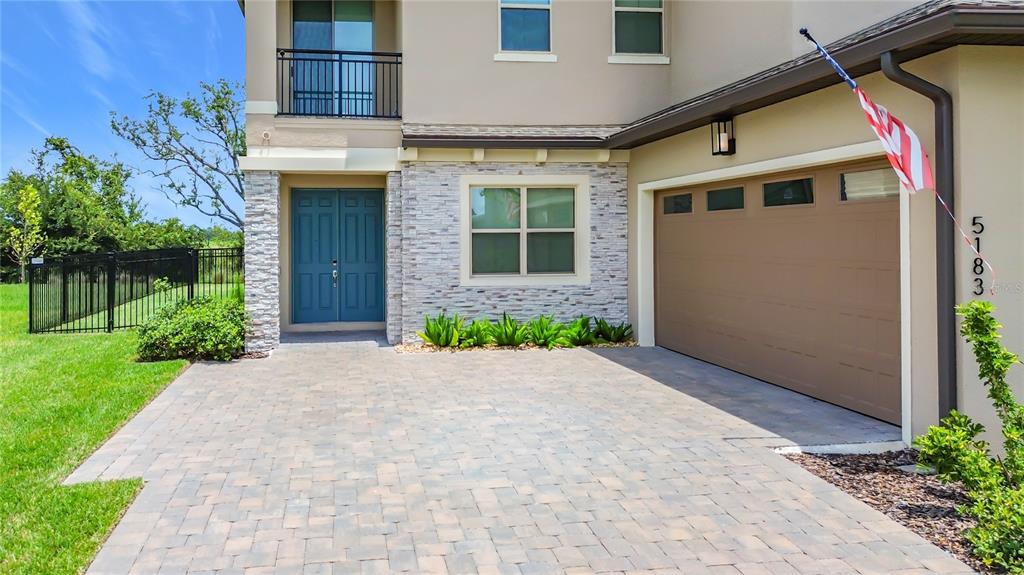 A paved driveway leads to the front entrance and garage of a two-story suburban home — 5183 BUTTONSAGE DRIVE, ST CLOUD, FL
