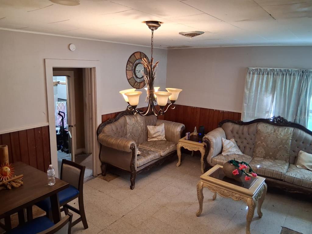 A living room features two ornate sofas, a chandelier, and wood-paneled walls — 5741 NW 191ST PLACE, REDDICK, FL