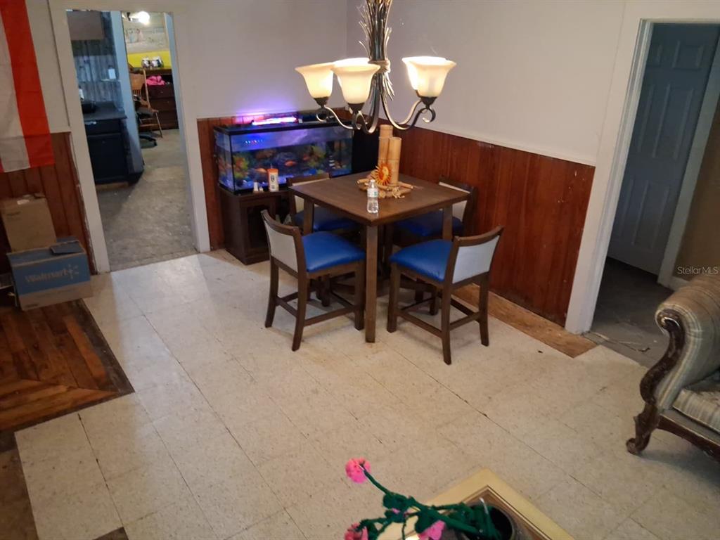 A dining area features a square table with four blue chairs and a fish tank — 5741 NW 191ST PLACE, REDDICK, FL