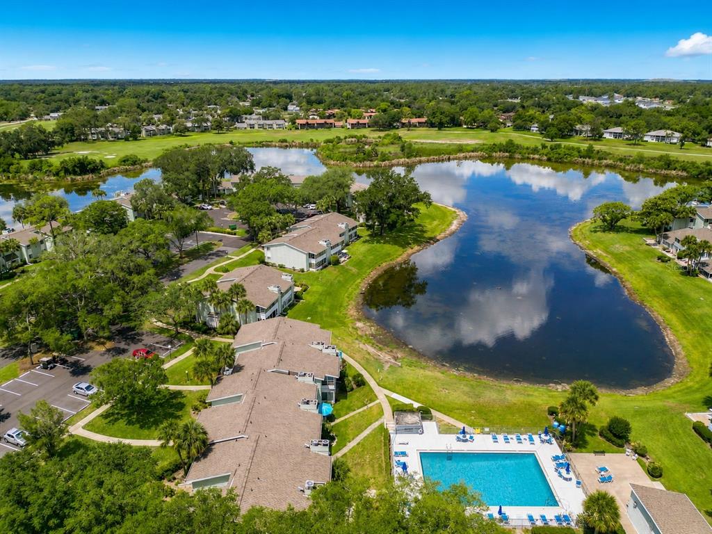 An aerial view shows apartment buildings, a swimming pool, and a lake in a residential area — 533 MIDWAY DRIVE UNIT B, OCALA, FL