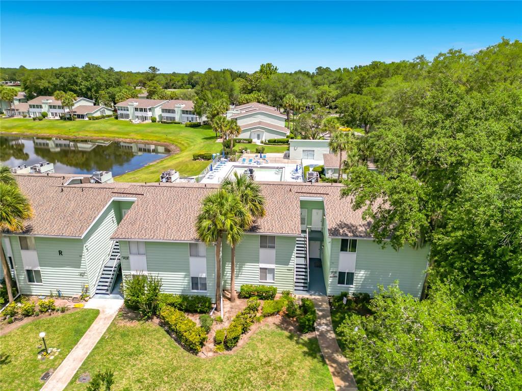 An aerial view shows a light green apartment building with a pool and pond nearby — 533 MIDWAY DRIVE UNIT B, OCALA, FL