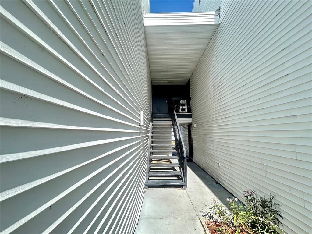 A black six-panel door with the number 705 is set in a white-sided exterior wall — 705 HAVEN PLACE UNIT 705, TARPON SPRINGS, FL